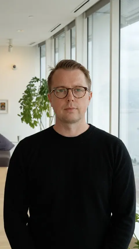 Paul's twin in a bright office with tall windows